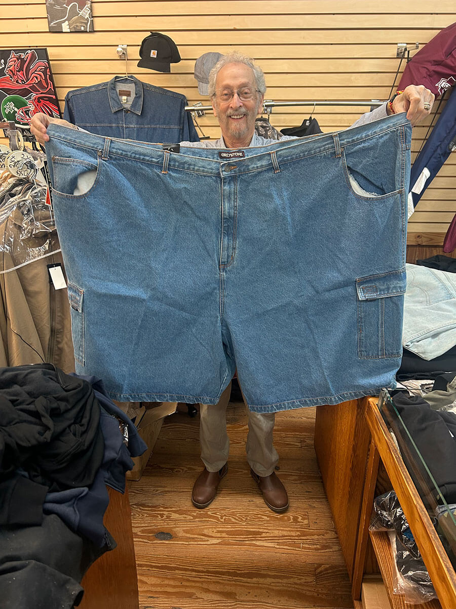 Bubba Kornfeld holding an extra-large pair of Big & Tall denim shorts.
