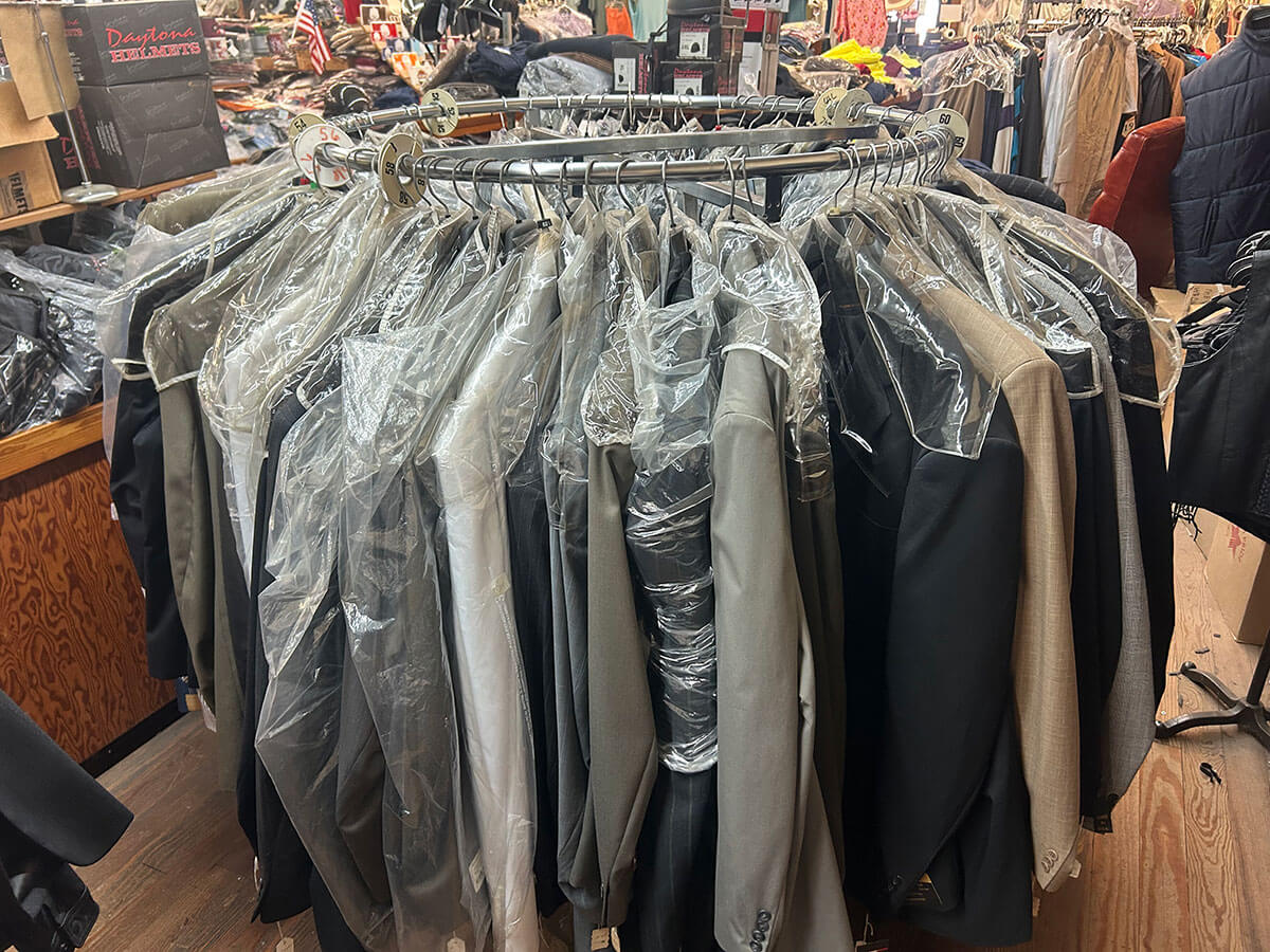 A rounder rack of suits and dress apparel in extended sizes at Kornfeld's.