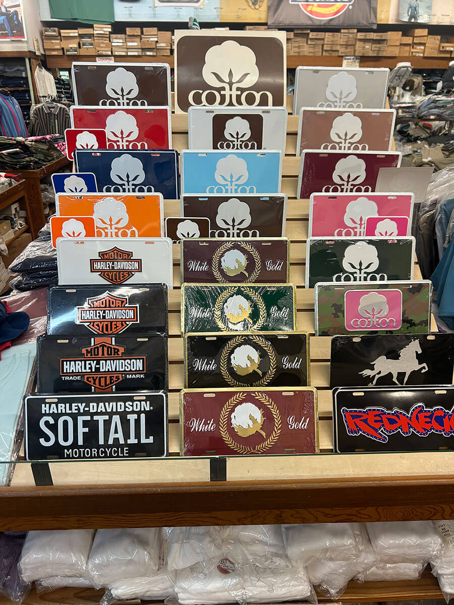 Display of novelty motorcycle and Cotton brand license plates and tags.