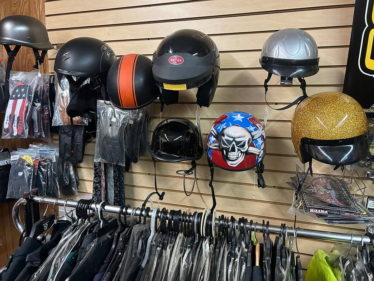 A wall of motorcycle helmets and riding gloves at Kornfeld's.