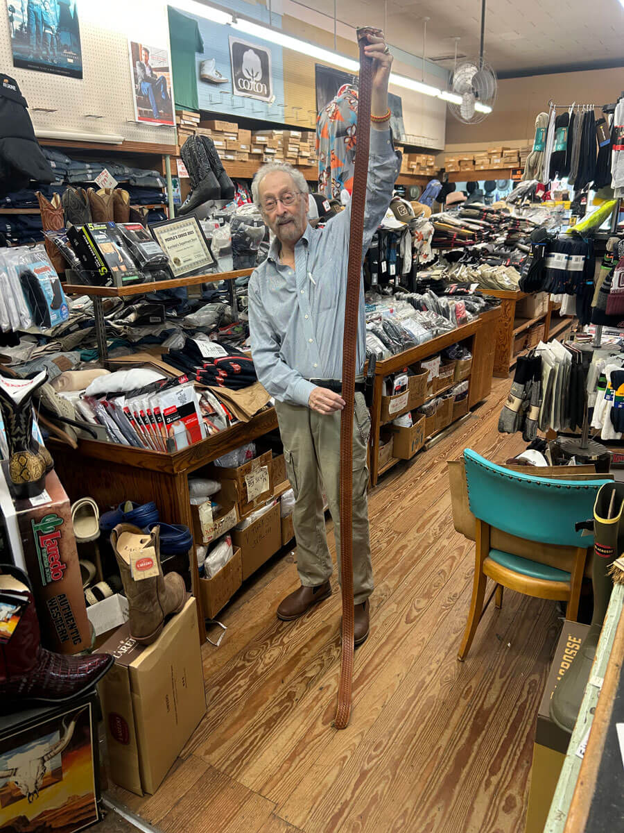 Owner Bubba Kornfeld standing inside Kornfeld's Department Store surrounded by boots, denim and accessories.