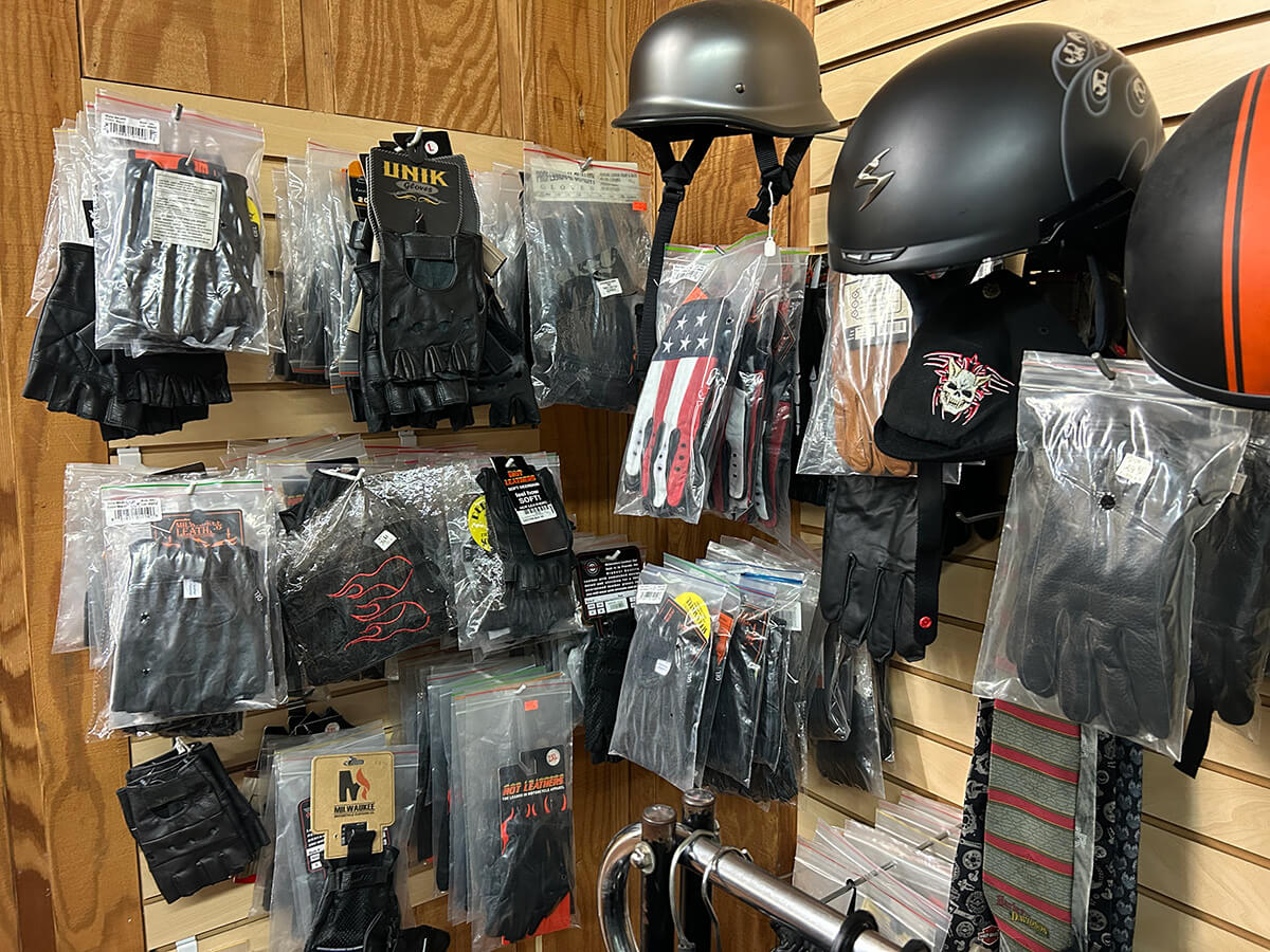 A wall display of leather riding gloves and motorcycle helmets at Kornfeld's.
