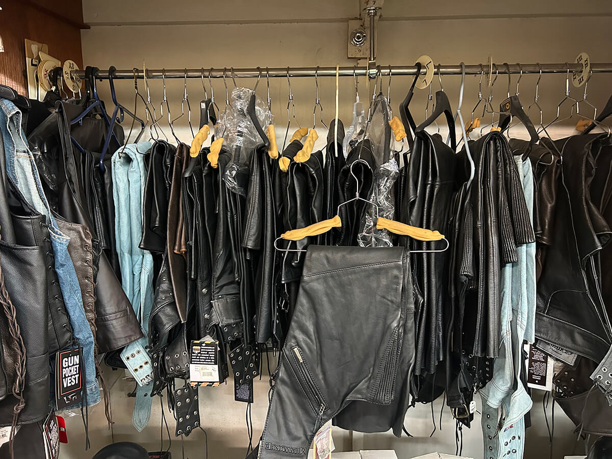 A rack of black leather motorcycle jackets and chaps at Kornfeld's.